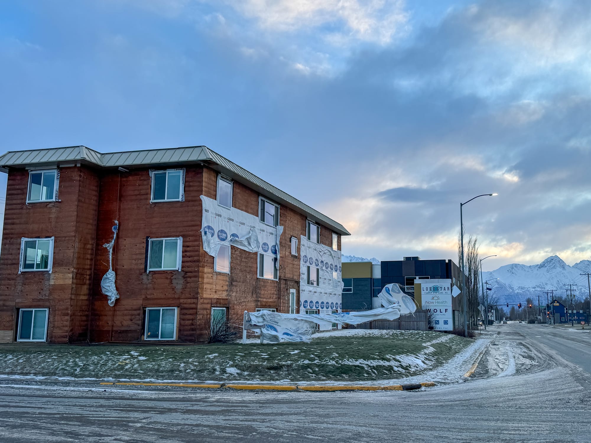 Building wrap flaps off a sign after ripping from a construction project in high winds in Palmer