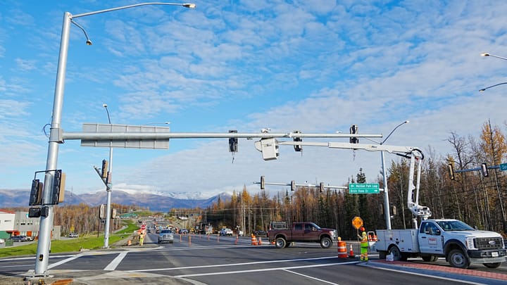 Construction crews work on a new light signal on Seward Meridian Parkway