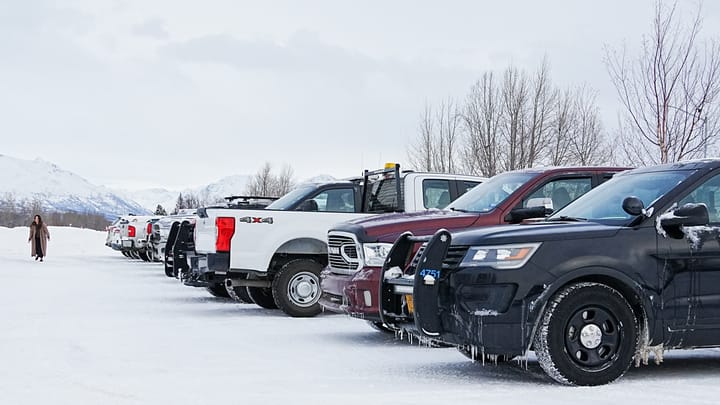 Vehicles sit in a parking lot next to the Palmer Depot