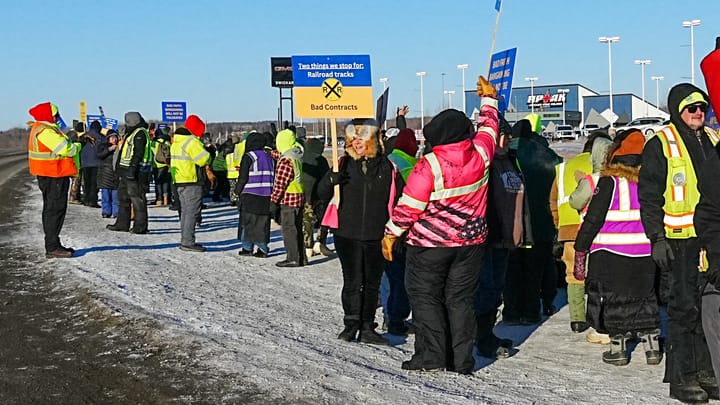 Bus workers wave signs on the strike line outside the Durham School Services