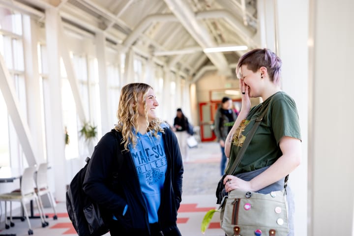 Students talk in a hallway at Mat-Su College